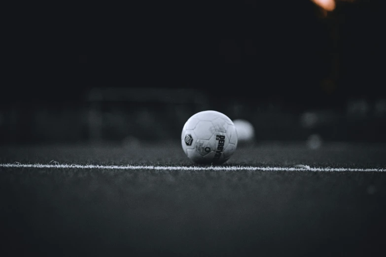 a football sitting on the ground in front of a field