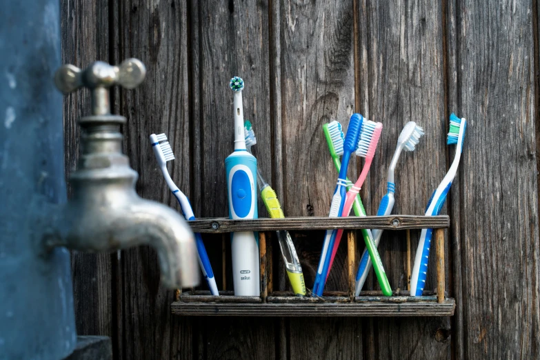 many different colored toothbrushes are grouped in a rack