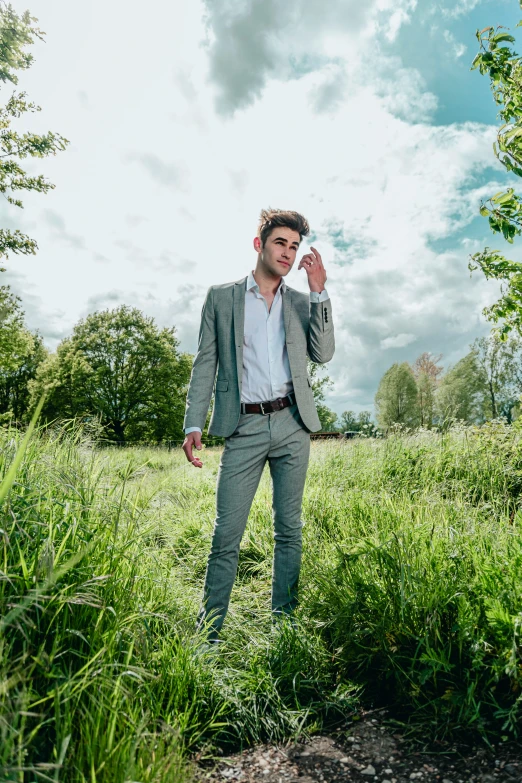 the man is standing in the green grass