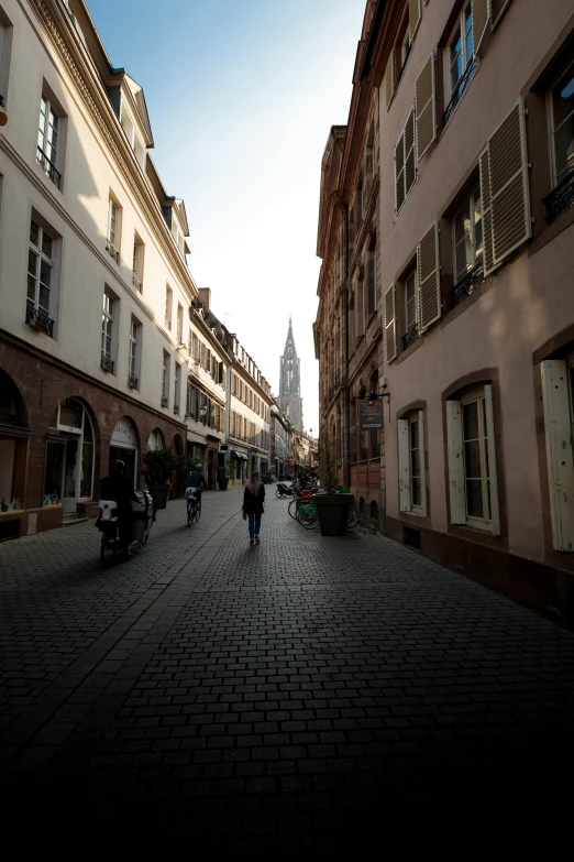 a woman is walking on the sidewalk between two large buildings