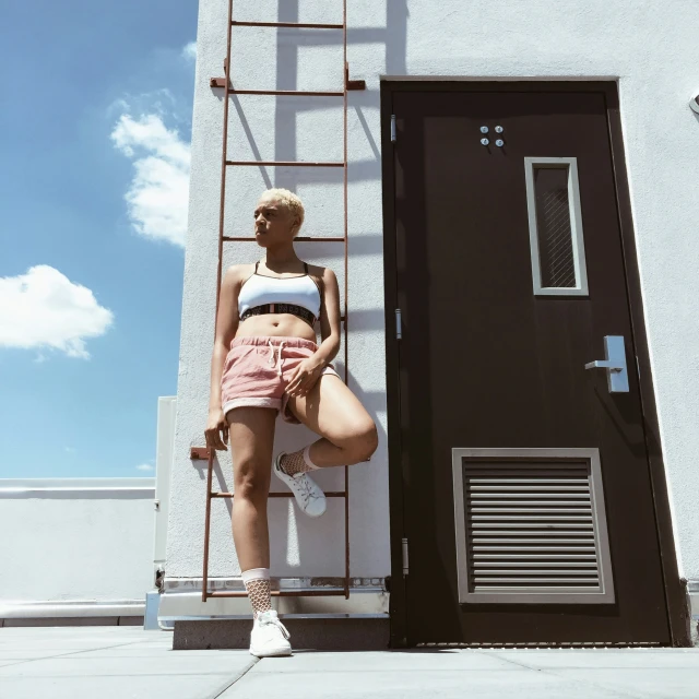 an attractive young woman leaning against a ladder