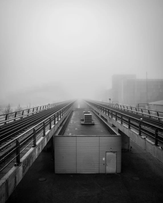 empty benches are near the tracks of an empty train station