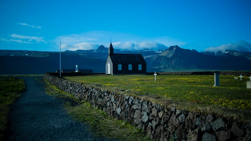 a church stands with tall mountains in the background