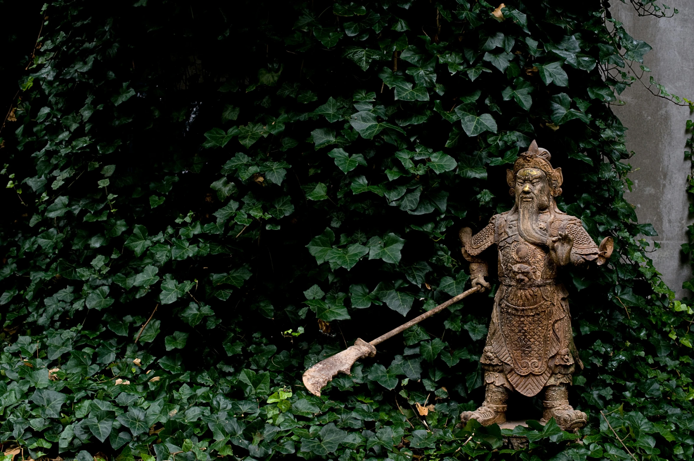 a garden statue in the center of ivy covered trees