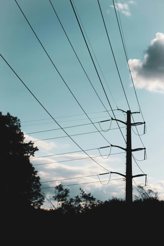 the silhouette of power poles with a blue sky in the background