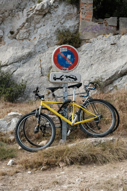 a bicycle and street sign on the side of a mountain