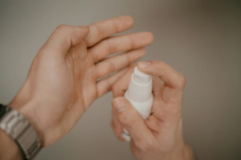 a person holding a bottle of hand sanitizer