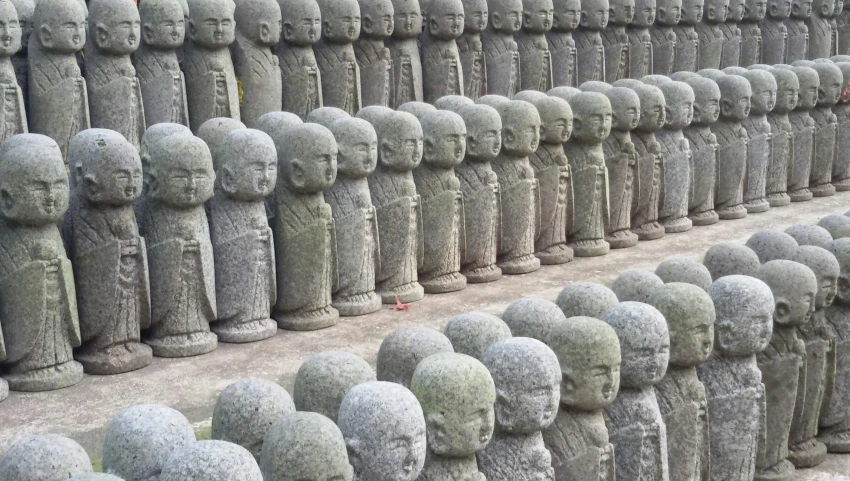 large grey statue heads next to each other on display