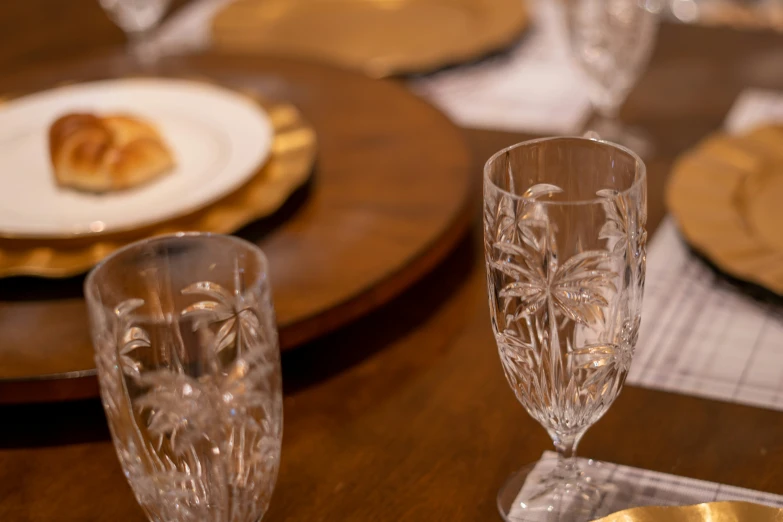 a table is set for formal occasion with clear flutes and plates