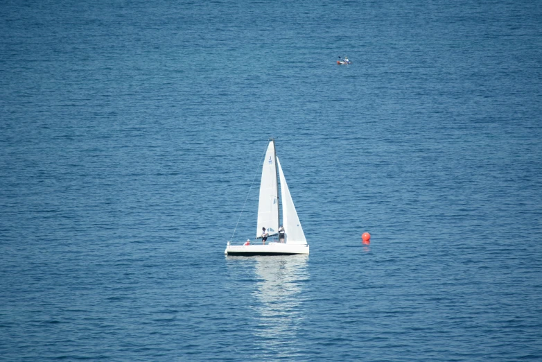 small white sailboat in the middle of calm ocean