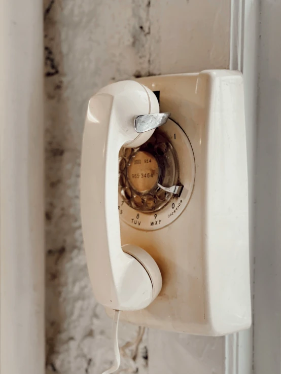 an old style telephone on the wall by the window