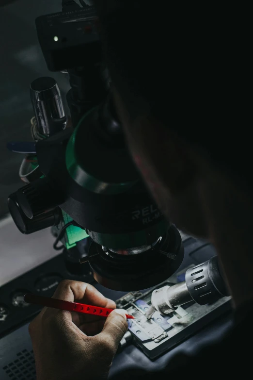 a man is writing on paper under a microscope