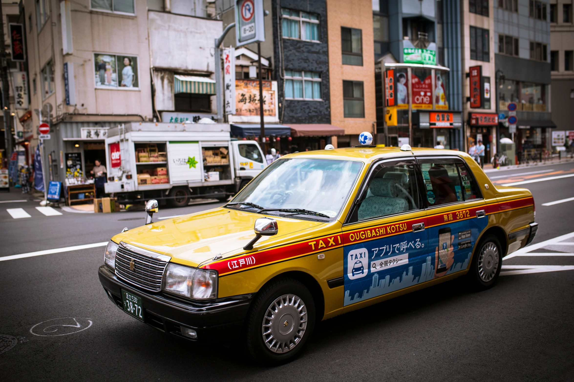 a taxi drives down a street in an asian city