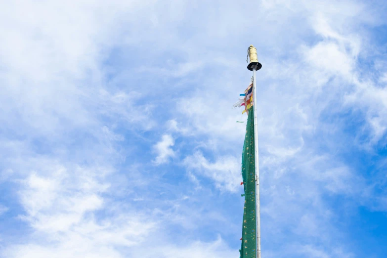 a green pole with flags on it with a light