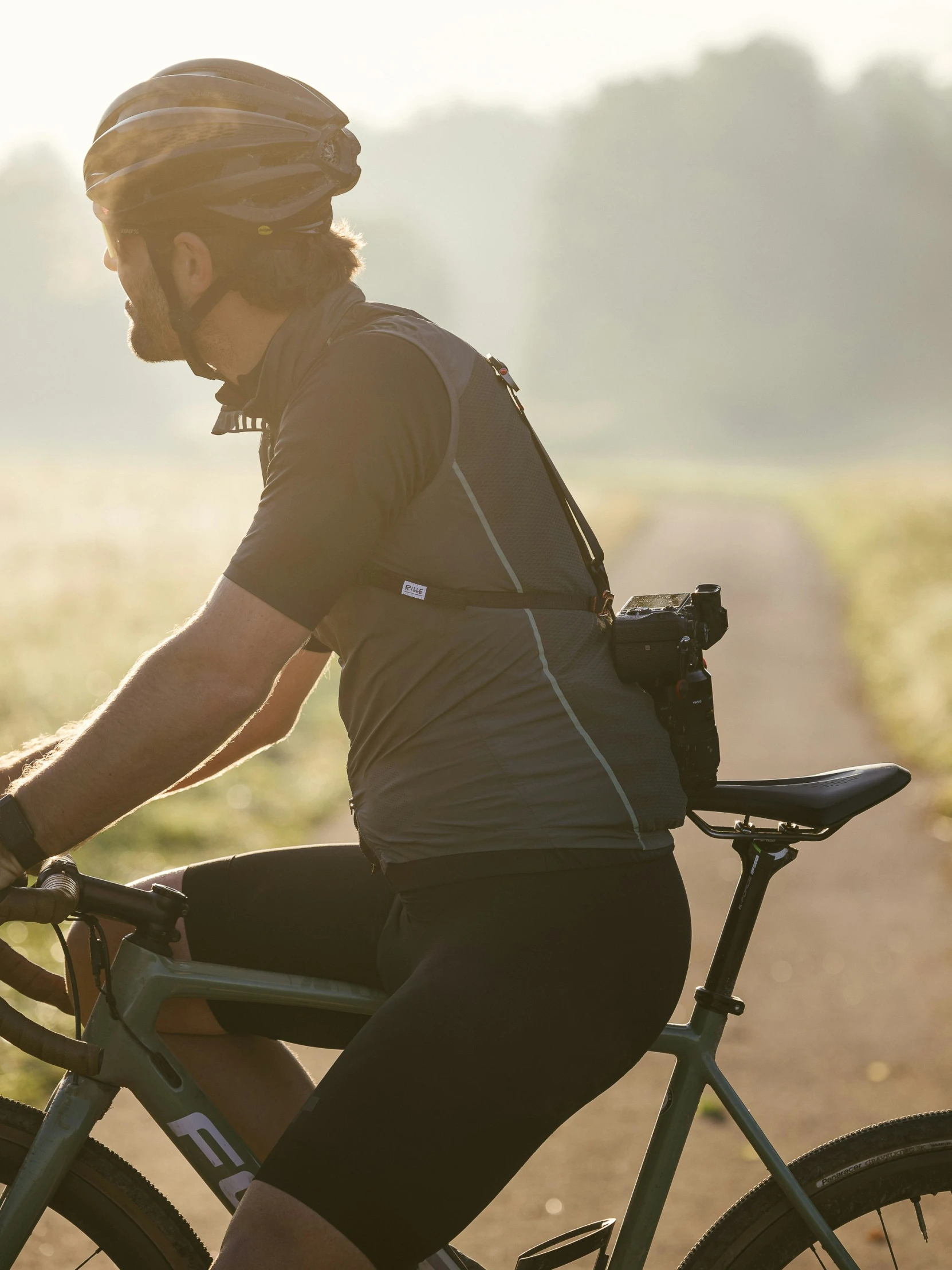 a man riding on top of a bike down a dirt road