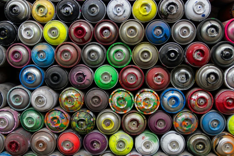 many different spools of colored paint are stacked together