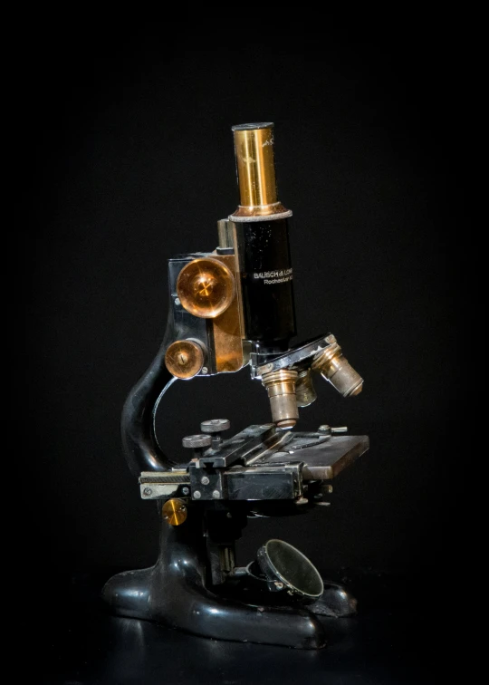 an old microscope sitting on top of a table
