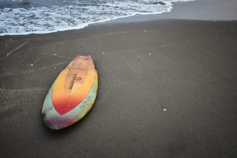 a surfboard on the beach with waves coming in to shore