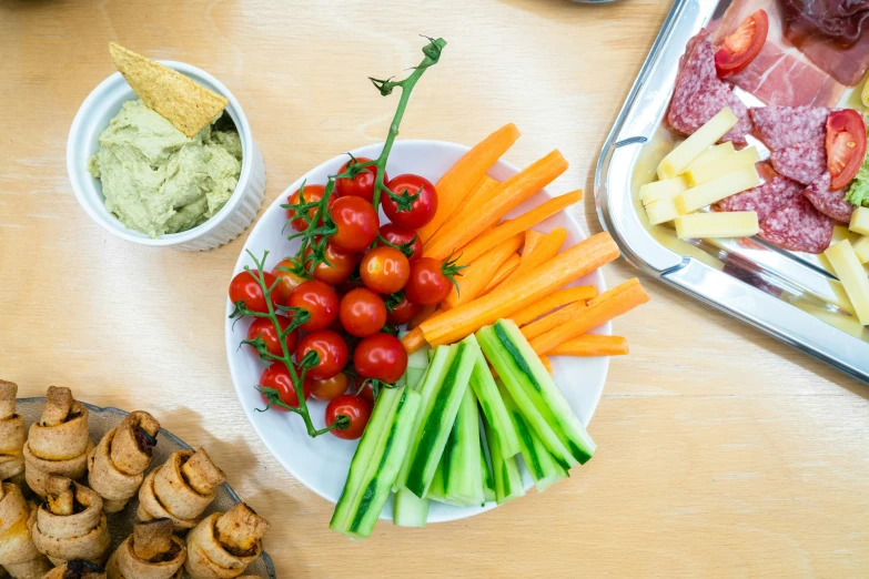 plate with vegetables and fruit on table, next to containers of food