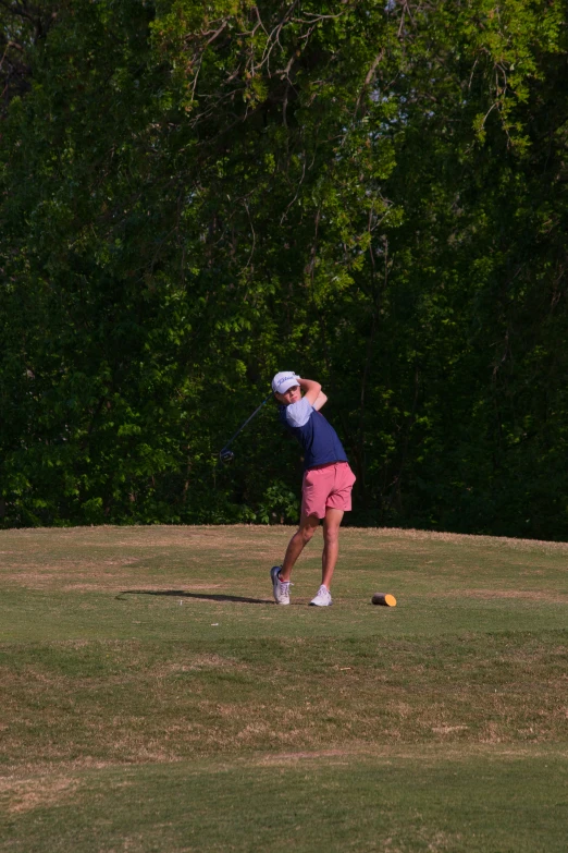 a man on the golf course swinging his tee