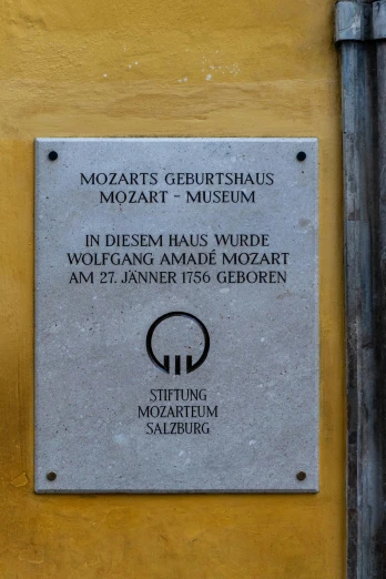 a plaque on the side of a building reads mozarti's gehrius mozaari, museum in divinia