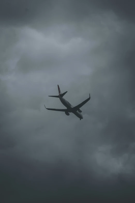 an airplane flying over a dark cloudy sky