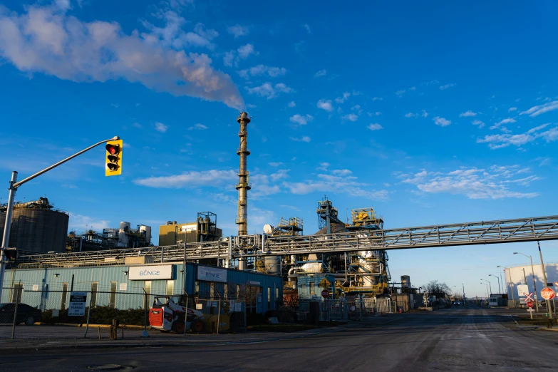 a factory and traffic signal sitting in the middle of a city street