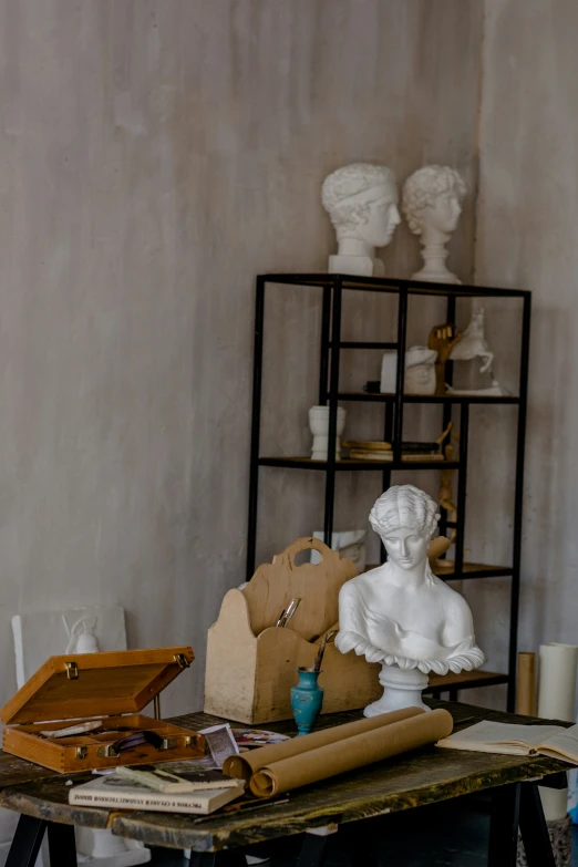 a sculpture of a seated woman surrounded by a collection of decorative objects