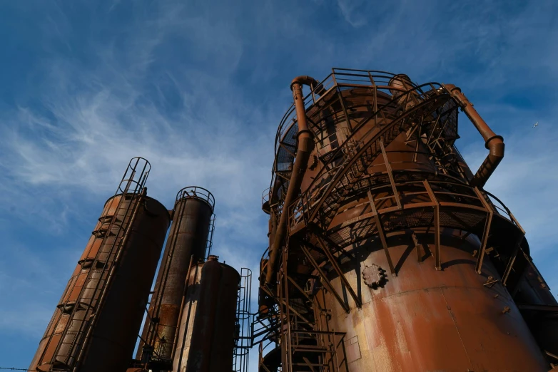 industrial steelludge against a blue sky with wispy clouds