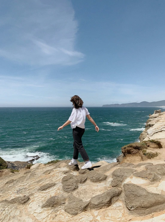 a woman standing on top of a large cliff