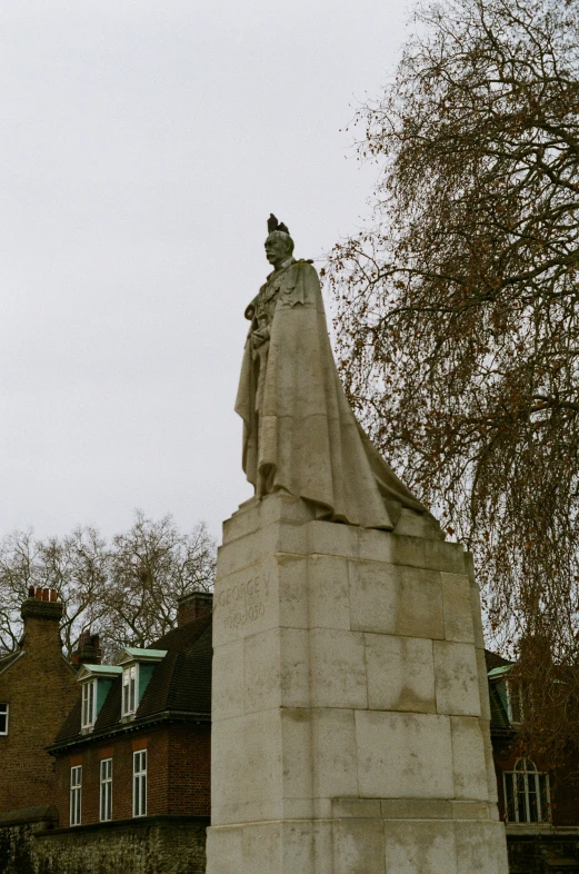 a very tall statue sitting next to some houses