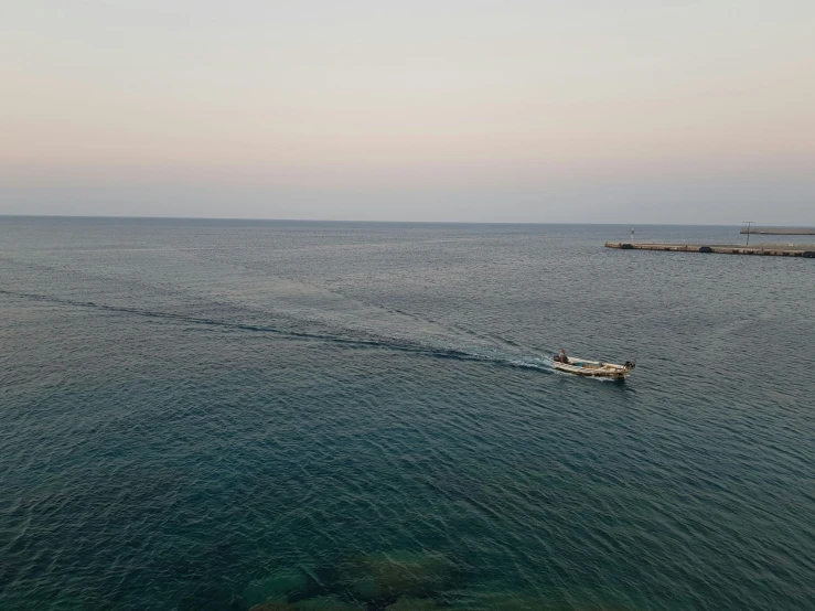 two boats are sailing across the water next to the shore