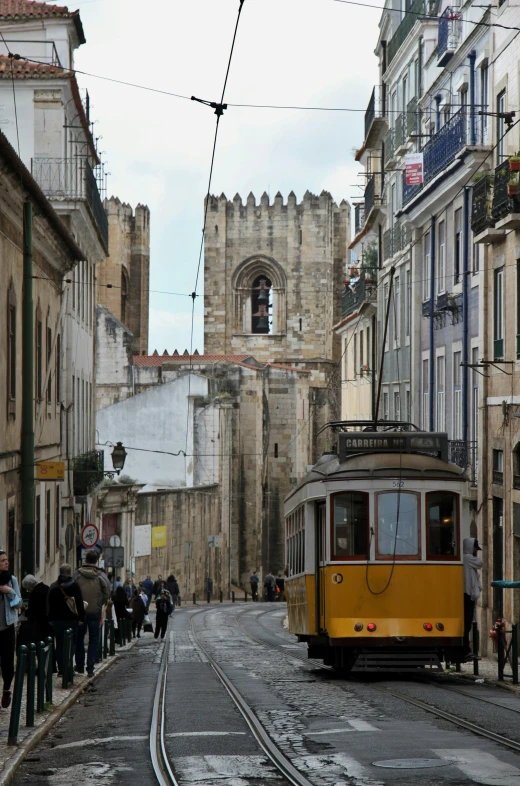 a tram that is going down the track and people walking