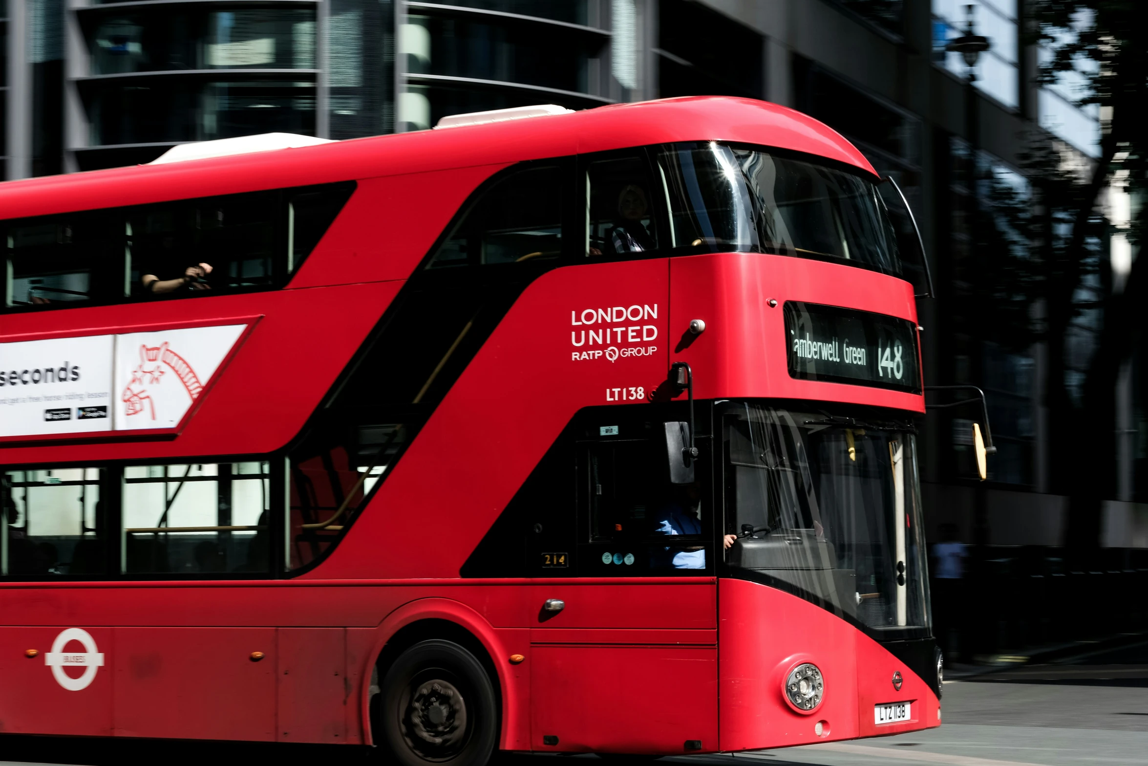 a red double decker bus with advertits on the side