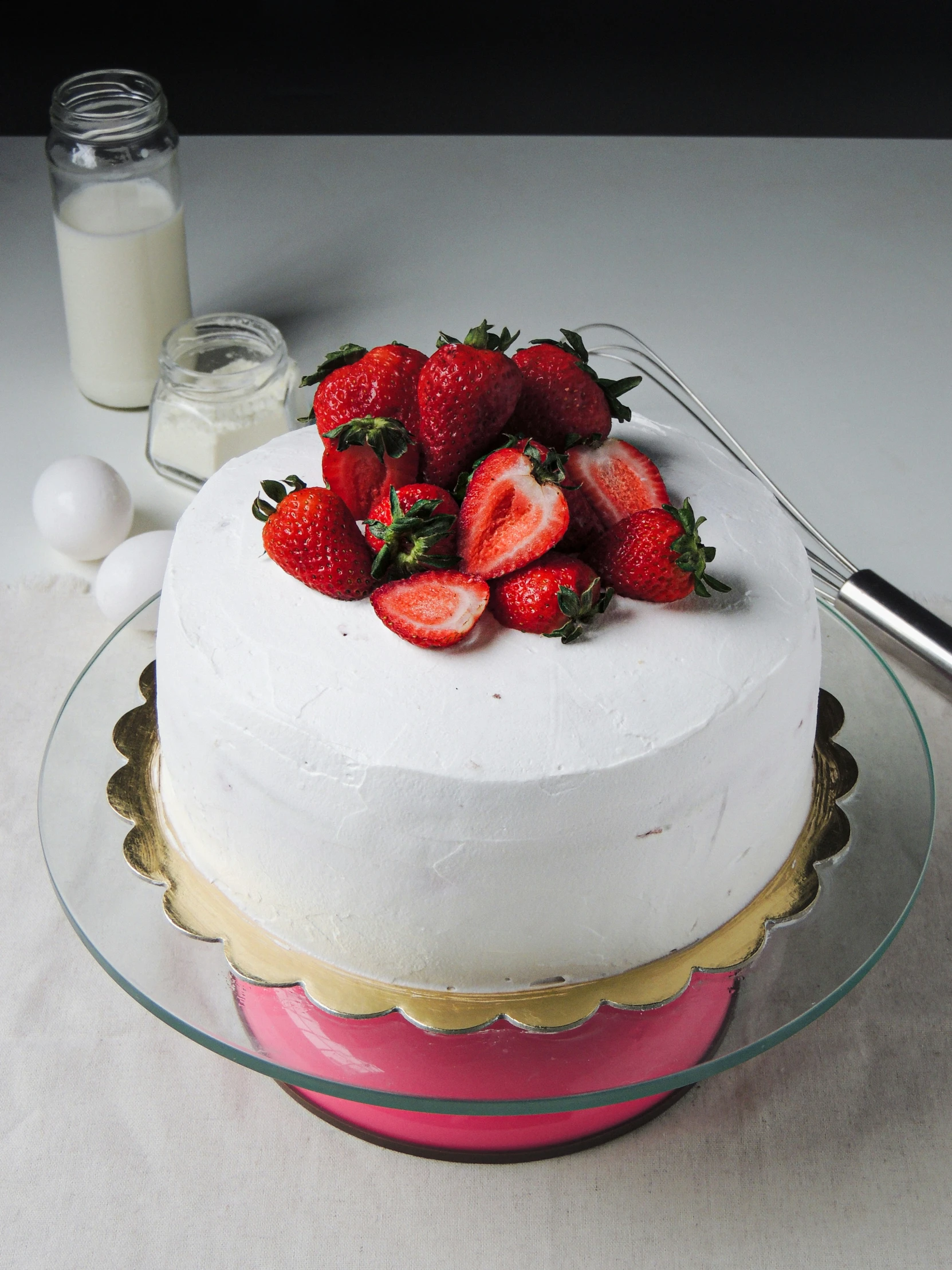 a large white cake has strawberries on top