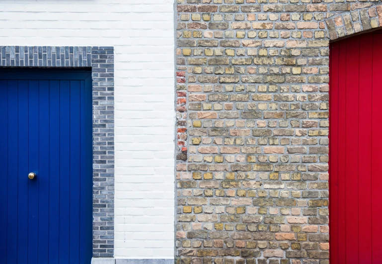 two doors side by side are painted bright blue and red