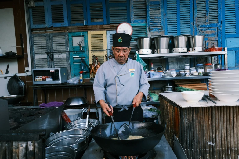 a man is cooking food inside of a pan