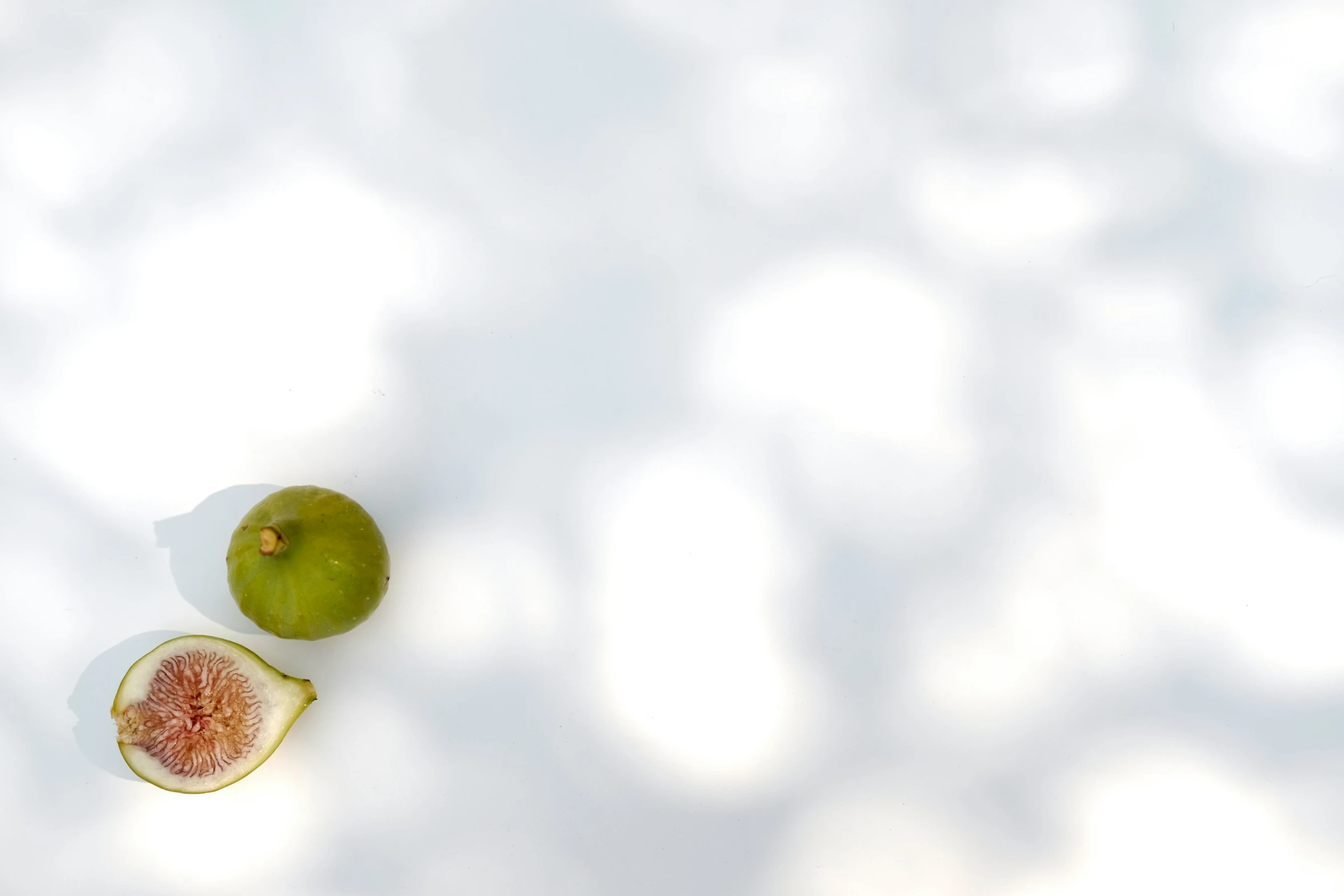 a sliced up green apple on a white surface