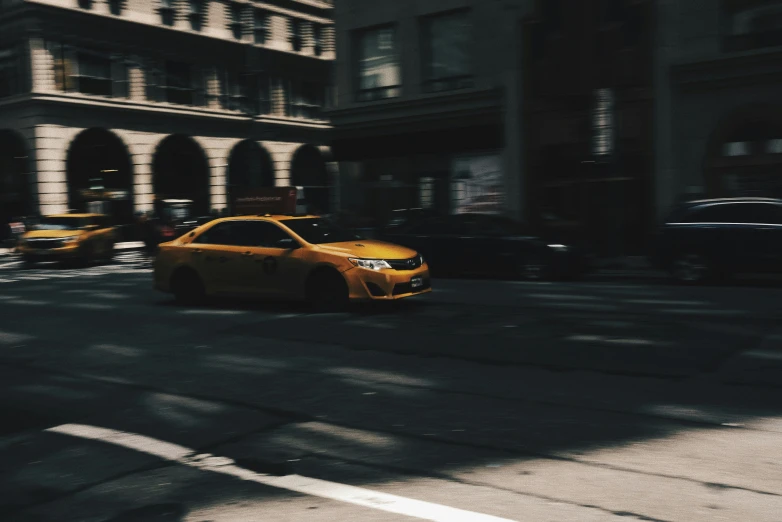 a taxi cab driving down a street under a traffic light