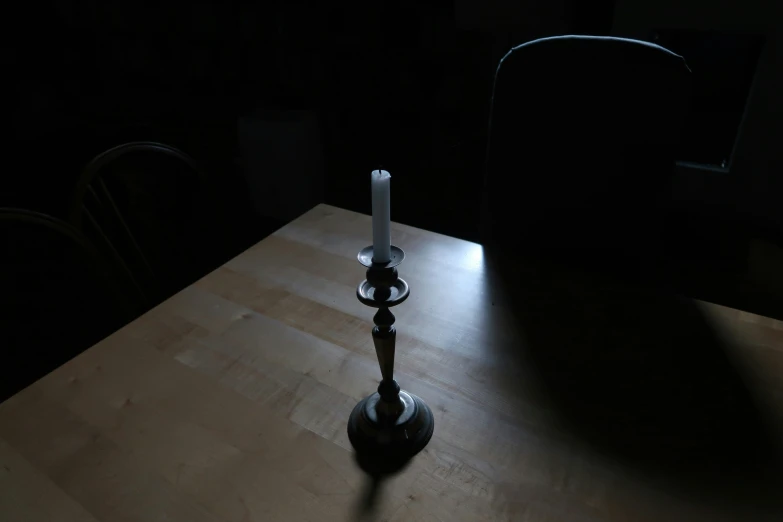 two white candles sitting on a wooden table