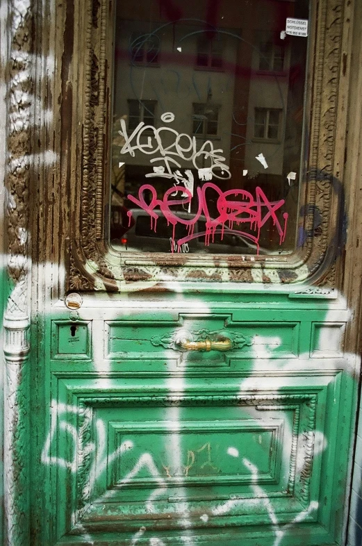 a green dresser with graffiti in the background
