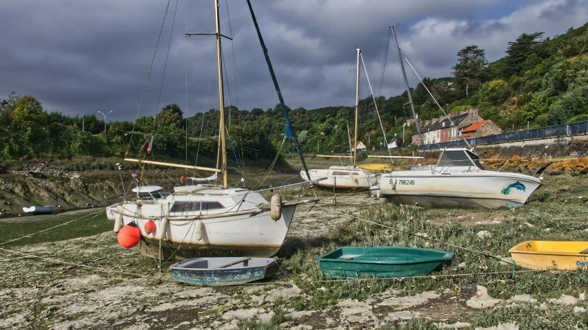 several sail boats in the sand on the side of the shore