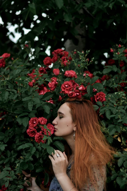 a woman with long red hair in a bush