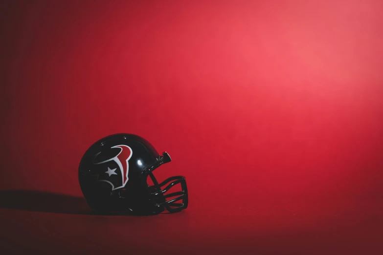 a football helmet sitting against a red background