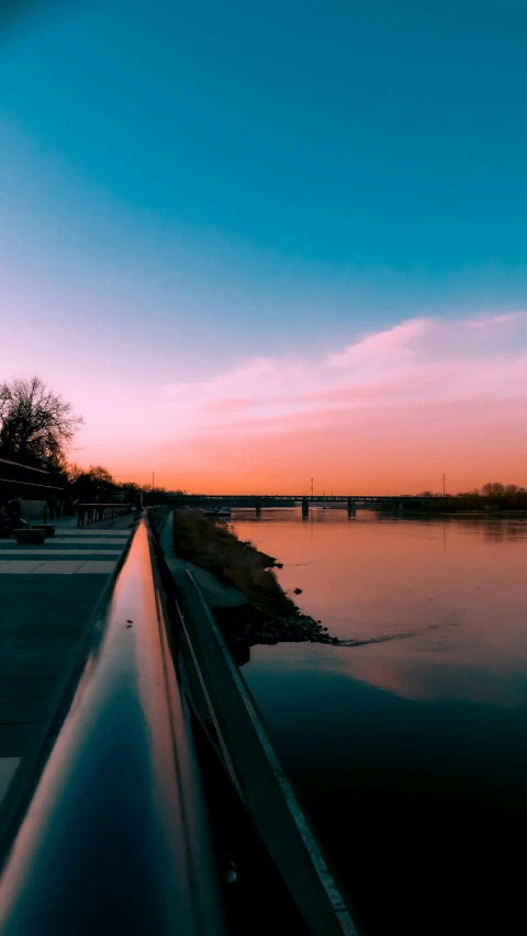 the sun is setting in the horizon at the lake