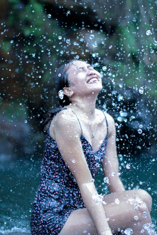 an image of a woman that is sitting down with water flying in her face