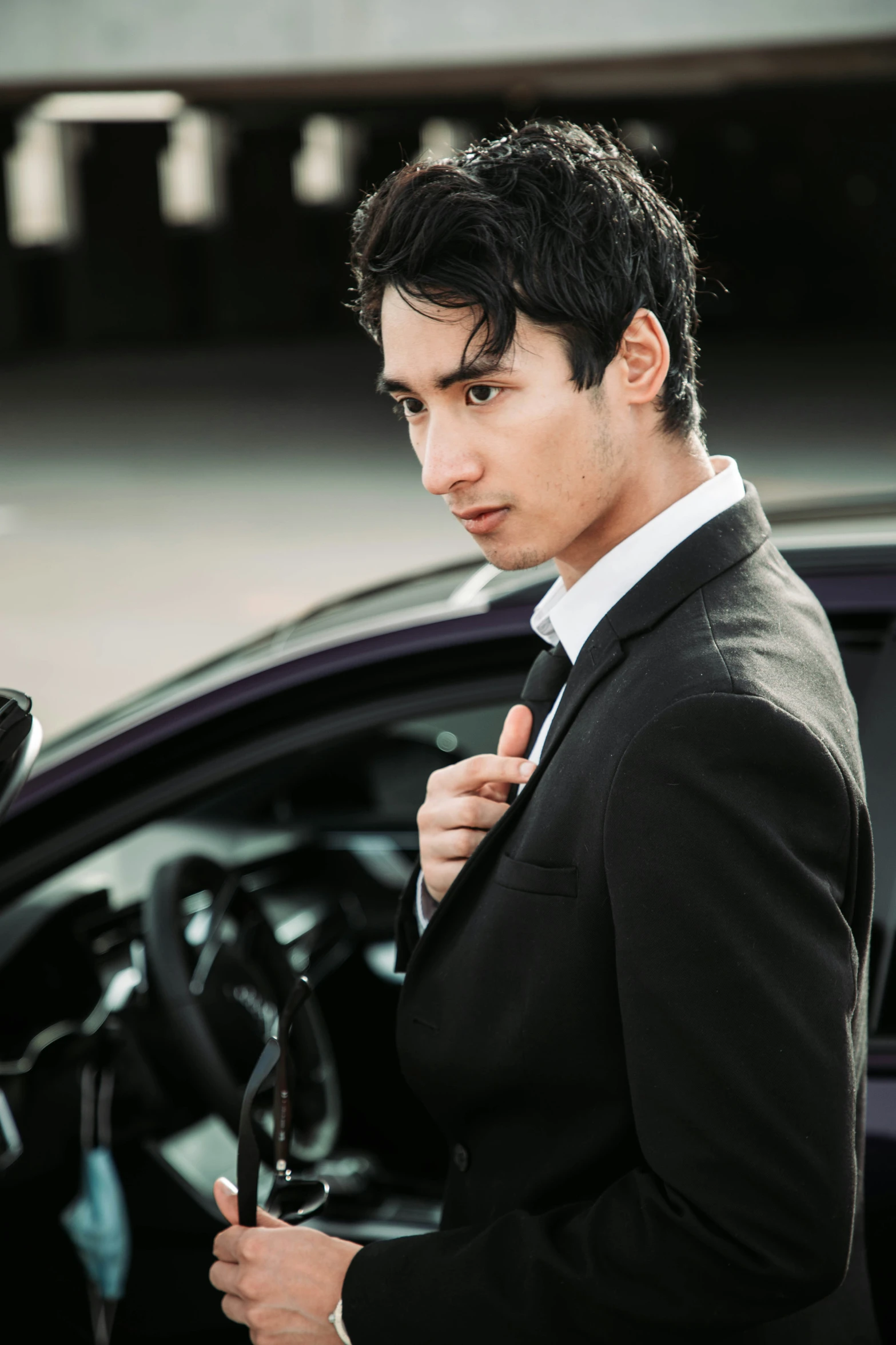 a man wearing a suit looking at his car door