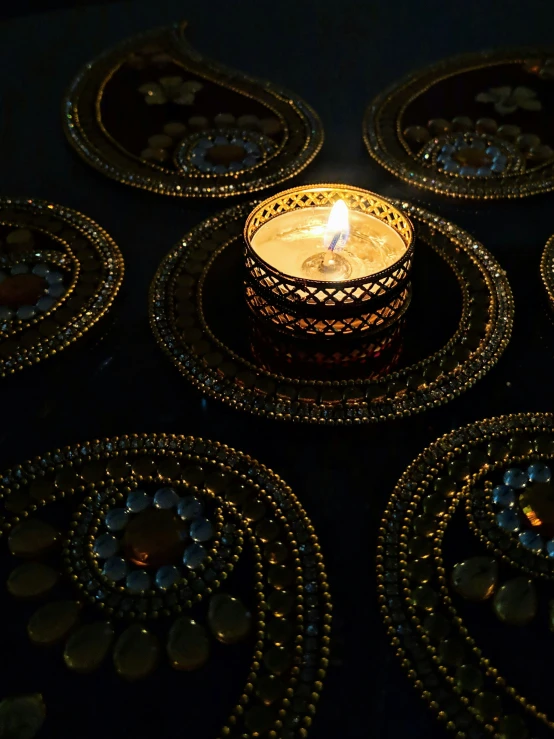 lit candle in middle of golden decorative circles