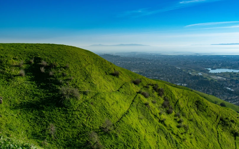 view over a grassy, wooded ridge in the mountainside