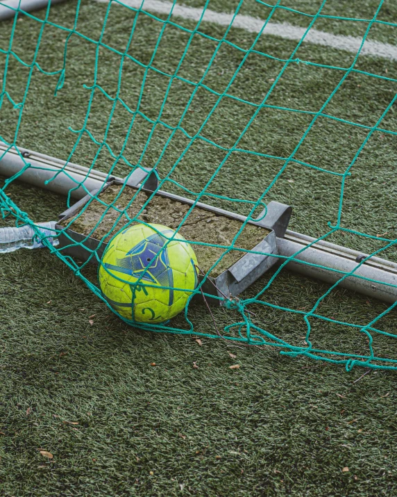 a soccer ball laying on the ground next to a goal post